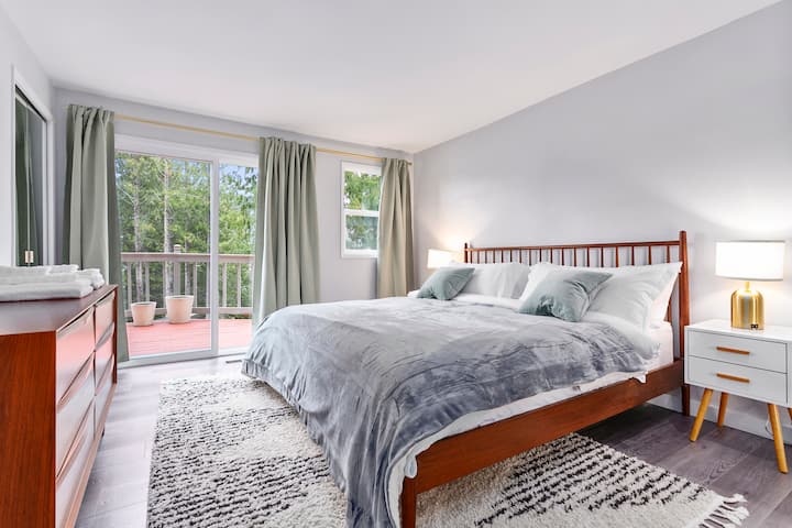 Spavaća soba na glavnom katu s bračnim krevetom i kliznim vratima kako biste mogli izaći ravno na terasu. Noćne svjetiljke uključuju USB priključke za jednostavno punjenje telefona. 