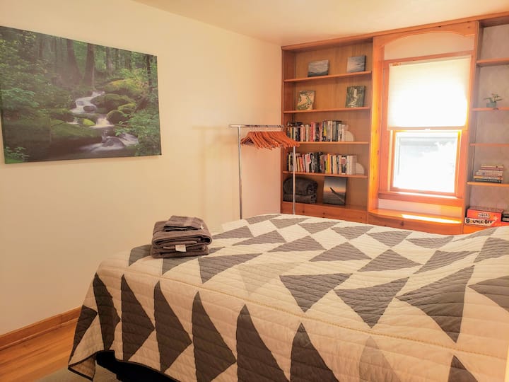 A first floor bedroom with a queen sized bed and plenty of natural light.