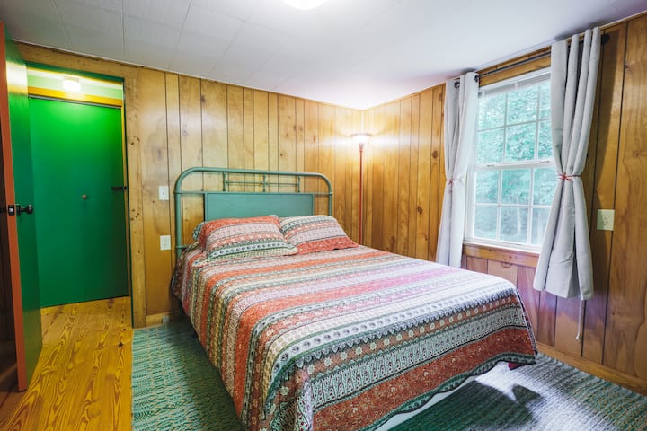 Chumba cha kulala kilicho na mapazia meusi na vivuli kwa ajili ya usiku wa kupumzika.  Dirisha linafunguliwa kwenye ua wa nyuma ambapo unaweza kusikia mkondo.   (Kitanda chenye ukubwa wa Malkia)