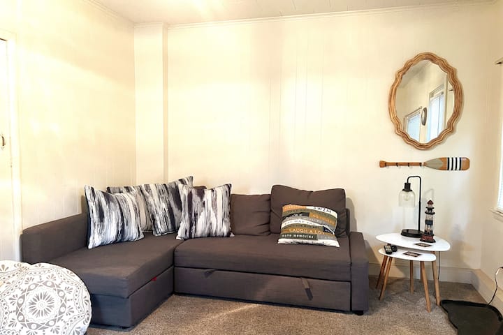 Penová matracová podložka a posteľná bielizeň sú naľavo od pohovky.  Zdvihnite a potiahnite úchytky, aby ste sa dostali do postele. 