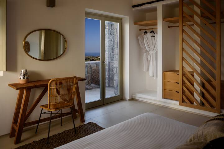 Dhomë gjumi e bollshme me krevat dopio të rehatshëm që hapet drejt një verande me pamje nga Deti Egje blu i thellë