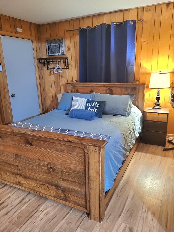 Room #1 - Queen size bed includes a shelf with hanger for hanging clothes, lamp, fan, a leather couch, TV with DVD player, and an electric fireplace. Sliding barn doors add extra asthetic and black out curtains for those mornings to sleep-in.