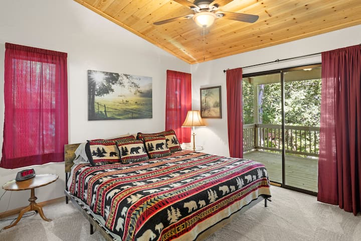 Hauptschlafzimmer mit einer 6 Fuß langen Glasschiebetür, die zur hinteren Terrasse mit Blick auf Christopher Creek führt.