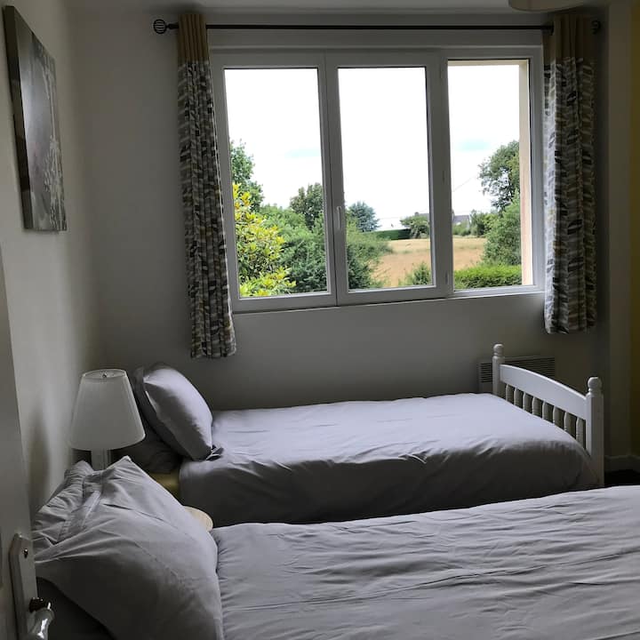 The bedroom with two single beds for children or adults, with its beautiful view of the countryside and the private garden of the cottage.
