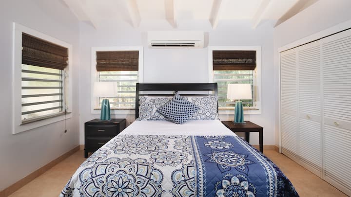 Queen size bed with Air Conditioning Unit in the Bedroom