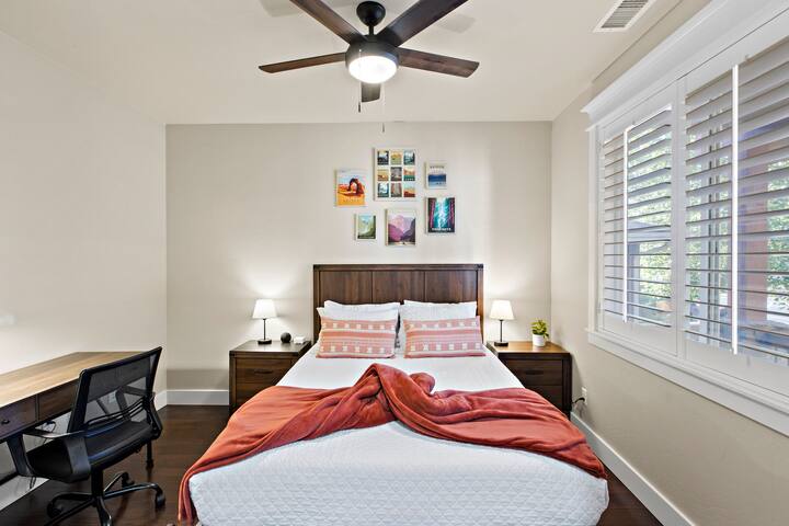 Beneden slaapkamer. Tuft en Needle Mint queensize bed met luxe beddengoed. Bureau en verstelbare stoel voor werken op afstand. Extra details zijn onder andere Alexa-luidspreker en oplaadlampen.