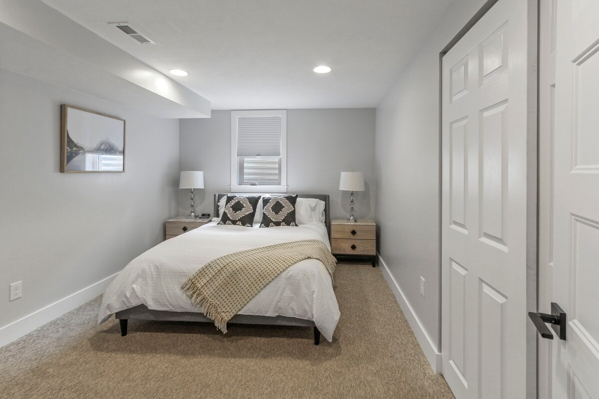 Spálňa v suteréne s manželskou posteľou a televízorom