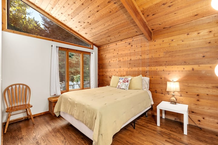 غرفة نوم ثانية في الطابق الرئيسي بسرير بحجم كبير وأغطية عالية الجودة. 