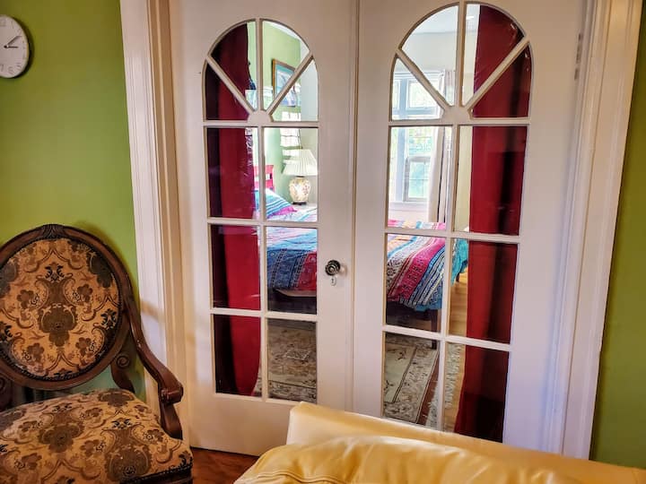 มองไปที่ห้องนอนผ่านประตูกระจกในห้องนั่งเล่น  ประตูมีม่านความเป็นส่วนตัว