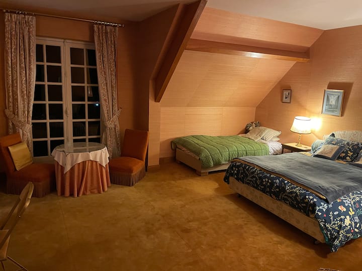 Chambre au premier étage avec un lit double et un lit simple