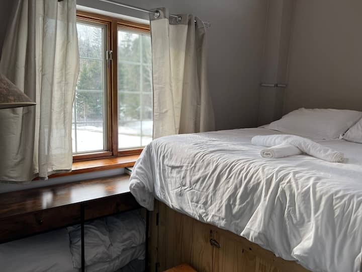 Das Schlafzimmer im Obergeschoss, das ein Queensize-Bett hinter der Küche enthält. 