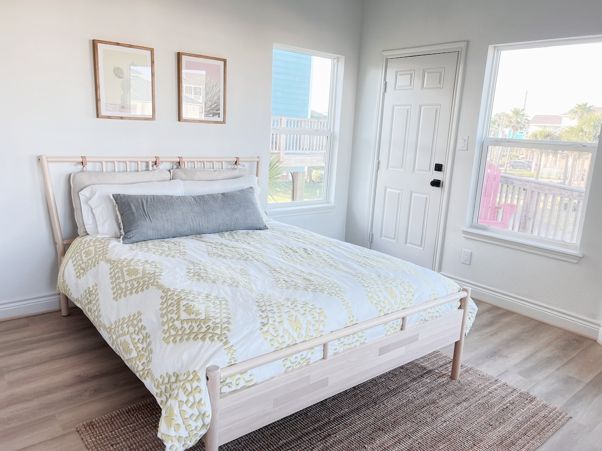 ห้องนอนหลักชั้นล่างพร้อมเตียงควีนไซส์ห้องน้ำในตัวและทางขึ้นดาดฟ้าด้านนอก