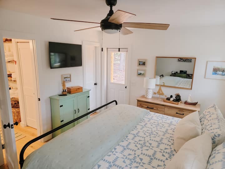 The master bedroom features a King bed, Smart TV,  and a door to access the back deck. Close off the bathroom door and the master bath and bedroom can feel like a master suite to guests. 