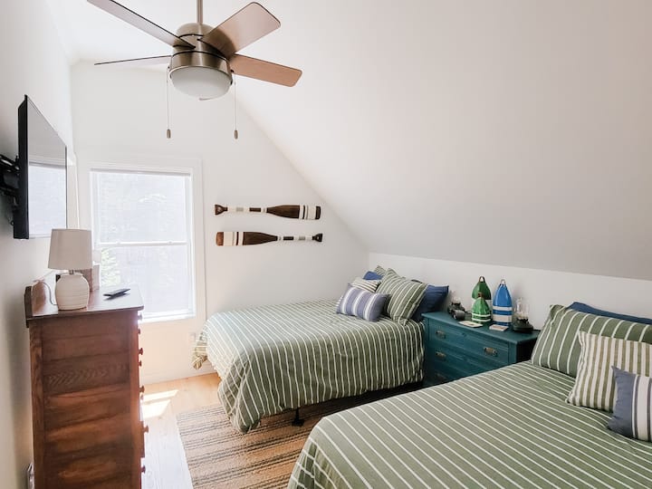 Two full size beds in the upstairs bedroom. Bedroom also has a smart TV, alarm clock and blackout shades. Upstairs closet has lots of extra blankets, access to vacuum, steamer, & portable fans. 