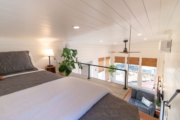 Cozy loft with a view overlooking the living space. Please note loft ceiling is low.

MrCool ductless mini-split offers heating and air conditioning - the large ceiling fan with adjustable settings circulates the air nicely throughout the Tiny.