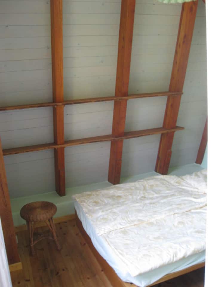 Nguo za likizo pia huja kwenye rafu za ukuta wa paa karibu na kitanda cha watu wawili.