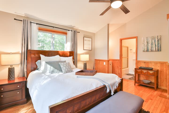 Bedroom #1 features a lofted ceiling with lots of natural light, a queen bed and a private en-suite bathroom with a bathtub.