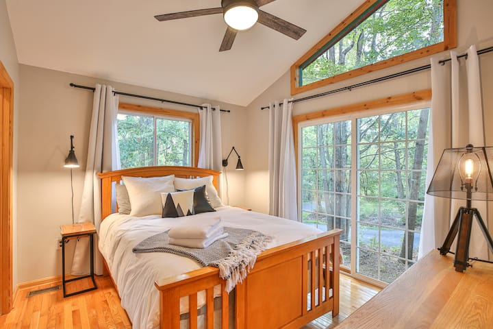 Bedroom #5 with en-suite bathroom features a queen bed with lots of natural light filling the room.  Bedside stands have USB charging outlets.