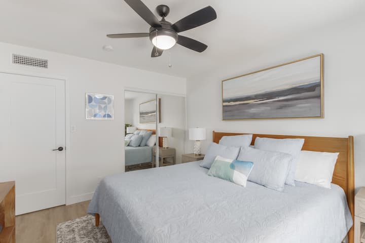 Hoofdslaapkamer met kingsize bed. Schuifkast heeft een dressoir verscholen voor opslag.