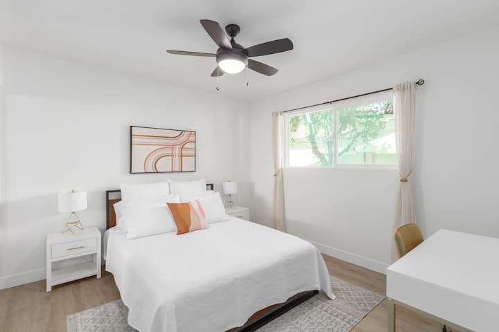 Kamer één met een queensize bed en een eigen werkplek met een comfortabele stoel.  Er is een extra dressoir verscholen in de kast voor extra opbergruimte.