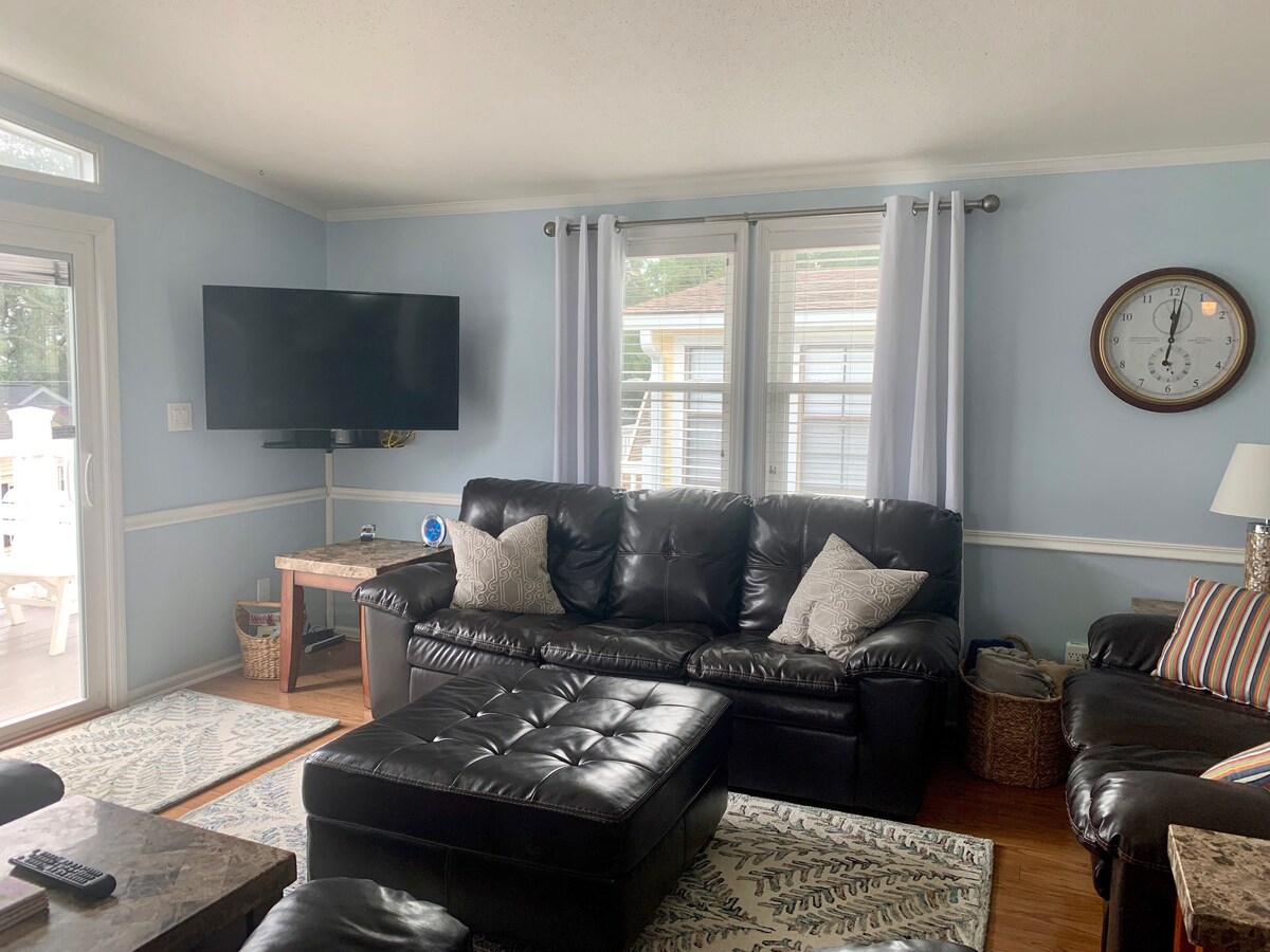 غرفة معيشة كبيرة ومفتوحة بسرير قابل للسحب ومقعد مزدوج وكرسيين بذراعين