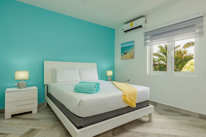 这间卧室配有一张标准双人床、一台空调和一个放松的桌灯。（主卧）