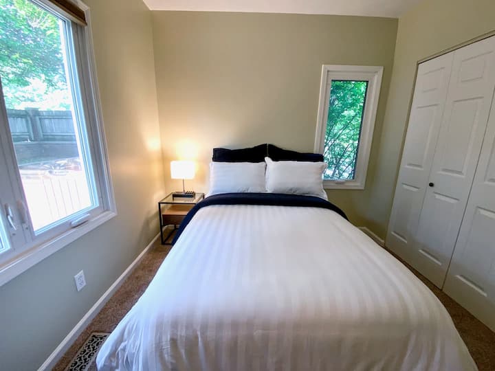 Dhomë gjumi standarde në katin kryesor. Llambë tavoline pranë krevatit me 2 priza AC, 3 porta karikimi USB dhe stenda telefoni prej druri