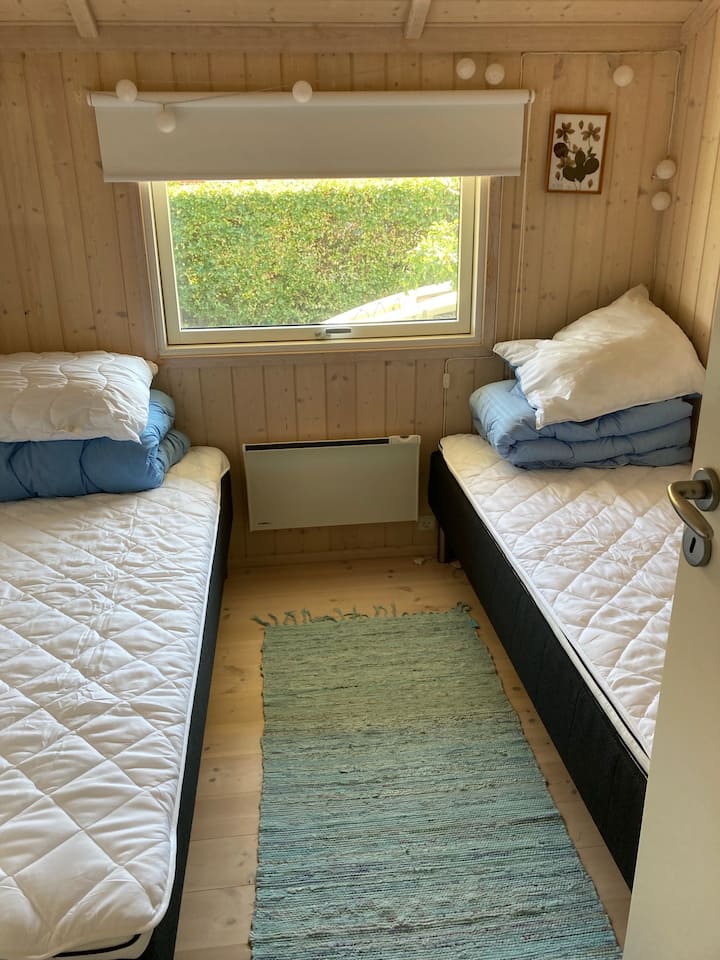 Dormitorio con dos camas de 70 x 200 cm. 
Un armario con estantes. 