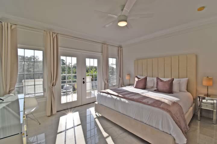 La suite principal de arriba tiene una cama tamaño king y acceso directo a la terraza con increíbles vistas a la terraza de la piscina y al bosque.