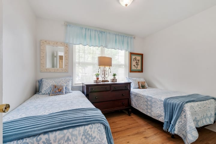 Dos camas individuales, un tocador con cajones grandes para guardar tu ropa. También un armario para colgar ropa en este dormitorio.