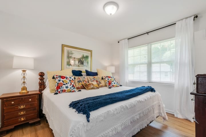 El dormitorio principal tiene cama tamaño king, dos mesitas de noche con almacenamiento, un armario de buen tamaño para colgar ropa y una ventana doble para mucha luz natural durante el día y persianas para la privacidad y buen sueño.