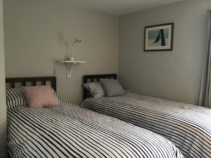 Spavaća soba 3 s prednje strane s pogledom na vrt s dva mala kreveta za jednu osobu koji se mogu spojiti s bračnim krevetom