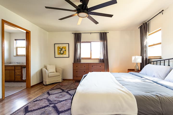 Retreat to the master bedroom featuring a king bed with a Casper memory foam mattress, high-quality sheets, and two pillow options for ultimate comfort. En suite bathroom with sliding barn door, 55 inch TV w/ Roku, and remote controlled ceiling fan.