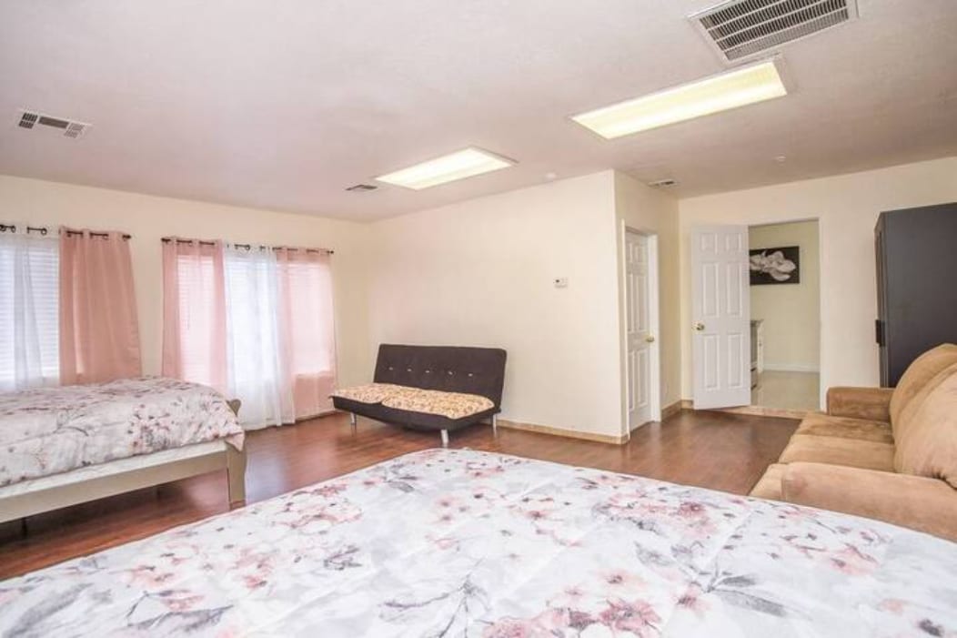 Проветрива спалня с леки завеси и удобни легла.