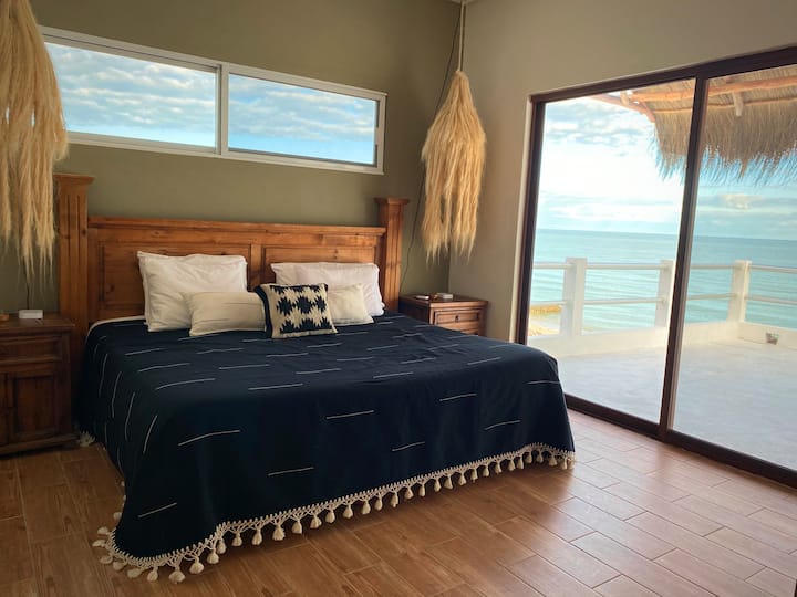 One of two primary bedrooms that overlook the ocean and have a balcony and ensuite bathroom.