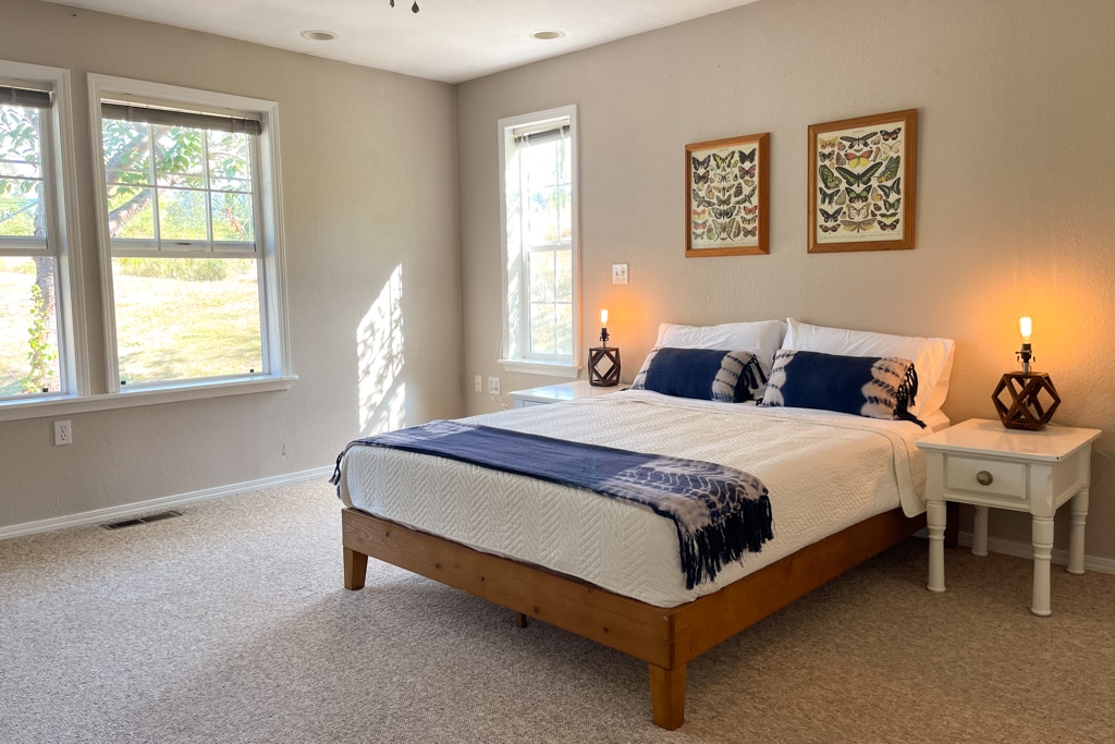 Спална соба бр. 2 со брачен кревет со поглед на задниот двор од 1 декар и црешово дрво, со зимзелен и планински поглед.