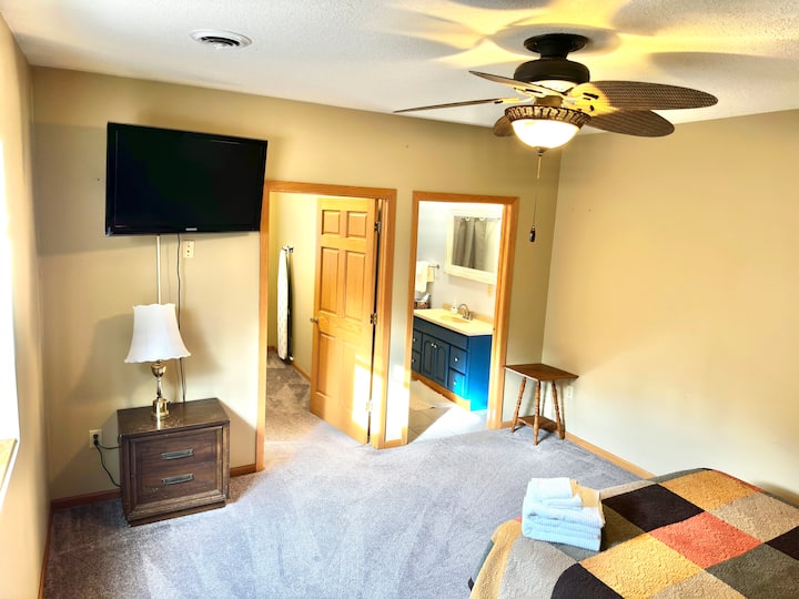 غرفة النوم رقم4 - الجناح الرئيسي. الطابق السفلي. سرير بحجم كوين، تلفزيون 40بوصة، حمام كامل ملحق، وخزانة ملابس ضخمة.