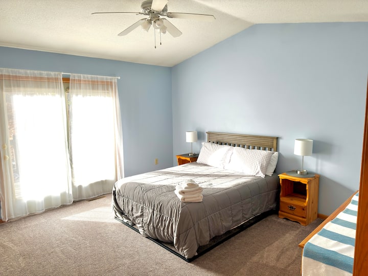 غرفة النوم رقم2 - جناح رئيسي بسرير بمقاس كوين. تدخل الأبواب الزجاجية إلى سطح السفينة الخاص في الفناء الخلفي.