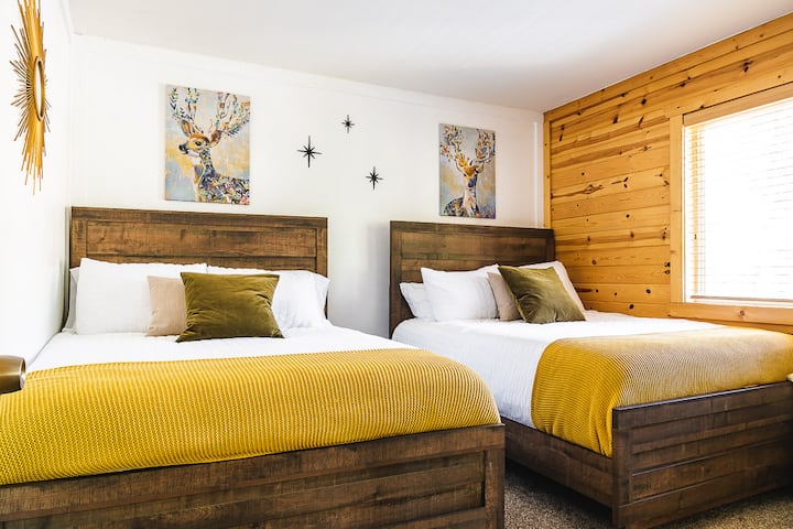 Dhomë gjumi në katin e sipërm me dy krevate me madhësi të plotë.