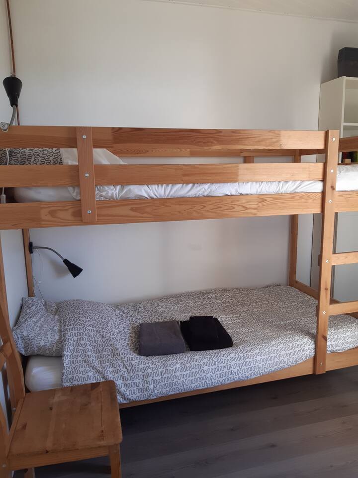 第二间卧室配有双层床，通往露台的法式门