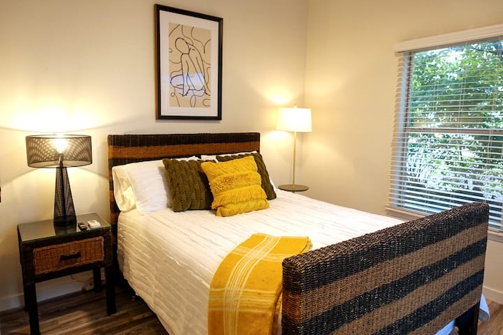 Cómodo dormitorio tamaño queen con iluminación cálida, obras de arte originales y todo lo que necesitas para una noche de descanso: un espacio acogedor para recargar energías después de un día completo en Fayetteville. (405)
