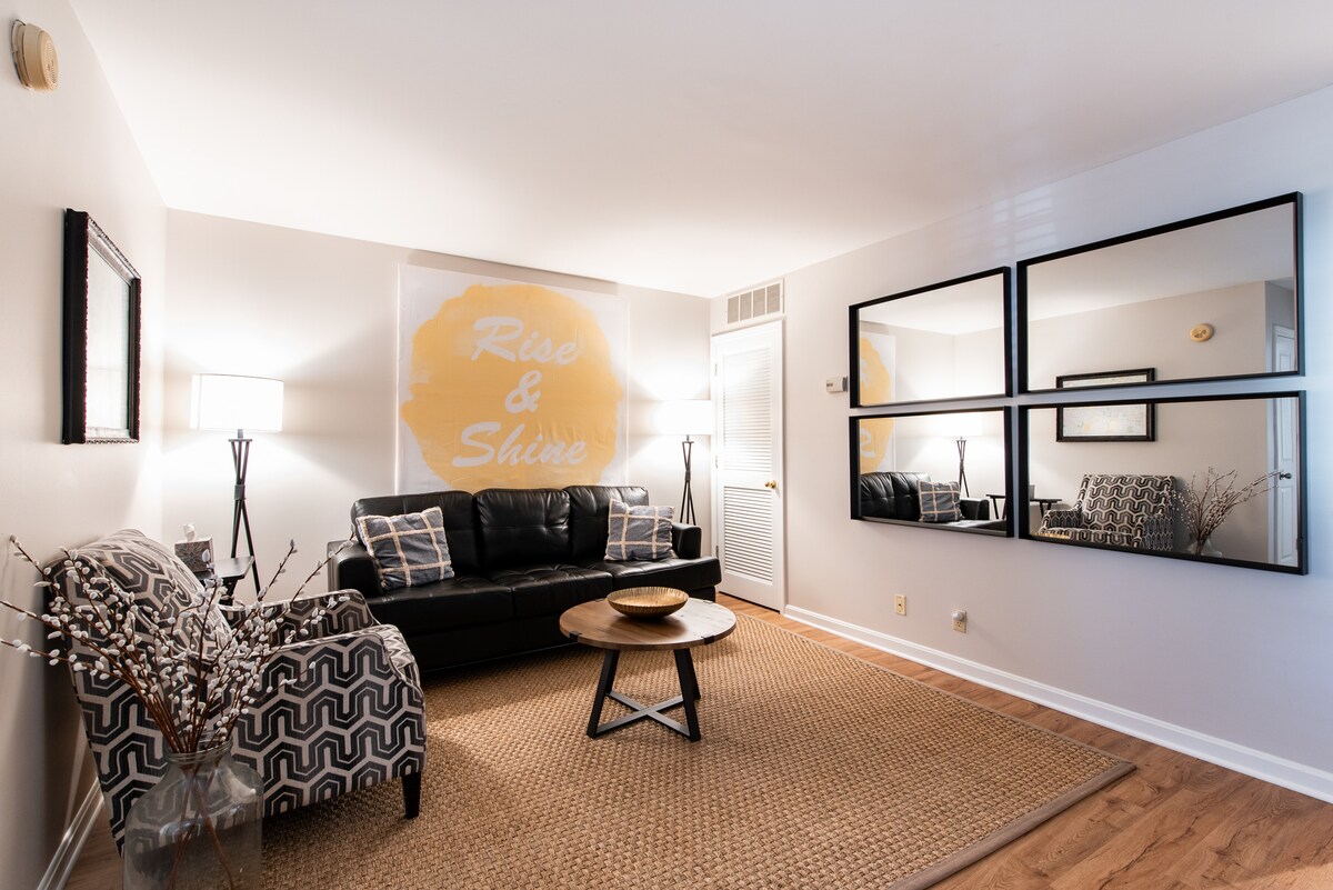 Front door leads to spacious living room with leather sofa. 