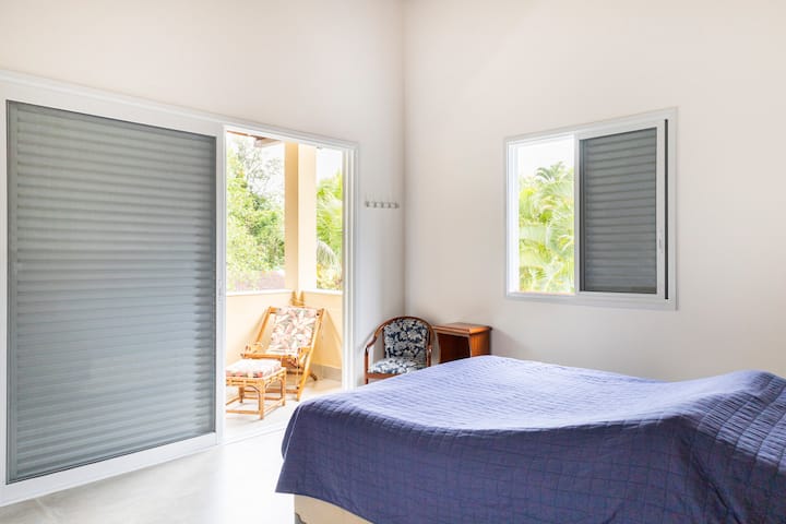 Двоен апартман со страничен прозорец и голема балконска врата со поглед на задниот двор.