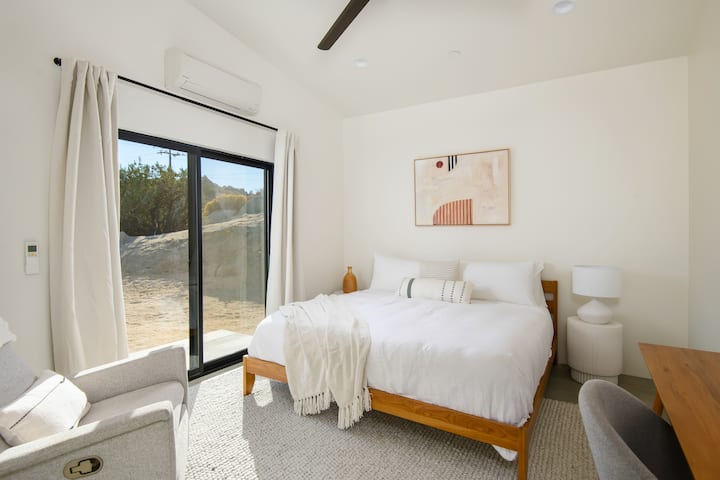 The second bedroom has a king sized Dreamcloud mattress and high end bedding, a recliner chair, a work desk with a comfortable work chair and a Sonos speaker