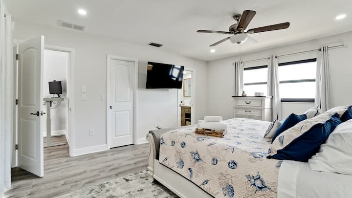 Master bedroom with a bathroom and a king bed. Retreat to your private sanctuary in this spacious bedroom, offering comfort and elegance with a touch of coastal flair.
