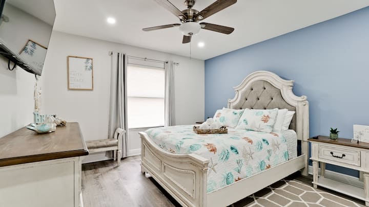 Bedroom 2 with a 50" smart tv and queen bed. A serene retreat awaits you in our beautifully appointed bedroom, perfect for a restful night's sleep.