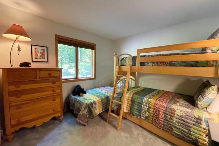 Bunk room with one set of twin bunks, one twin bed, and a twin trundle bed. 