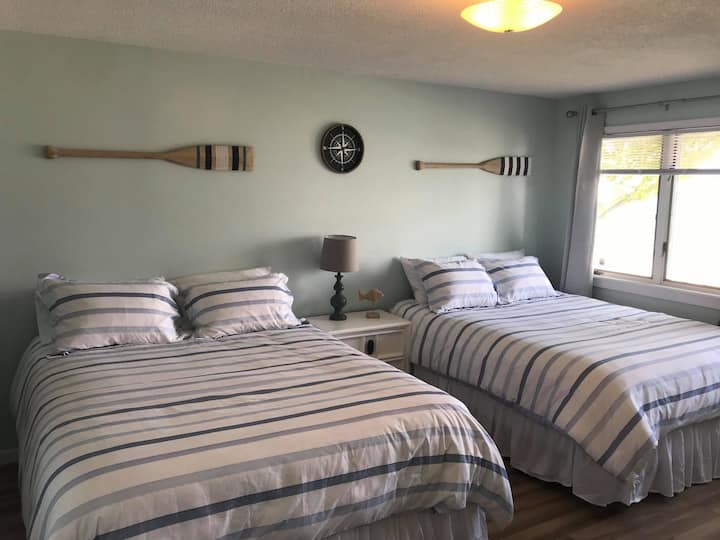 Dormitorio principal.  Dos camas tamaño queen con TV inteligente y medio baño.