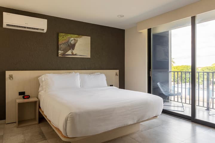 The bedroom with balcony has a king-sized bed that can comfortably accommodate two guests.
This bedroom is equipped with clothing storage, a smart TV, an iron (in the cabinet), and an air conditioner.