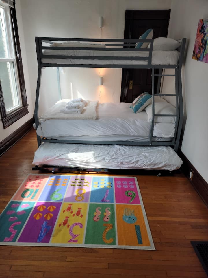 Cama de solteiro/gavetão sendo puxado para fora (sobre rodas).